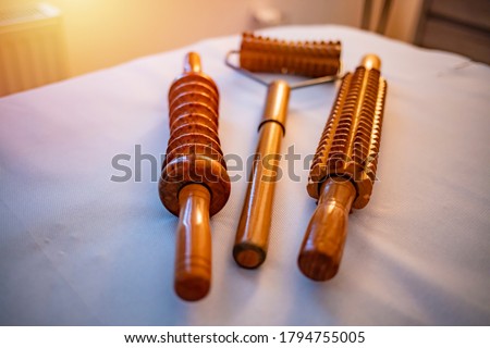 Wooden massage tools for Madero therapy. On the massage table is a tool for ant cellulite massage of Madero therapy. Wooden equipment for anti-cellulite maderotherapy massage in the salon