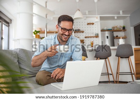 Shot of a mature man sitting on a chair in his living room using a laptop. Man with good vibes sitting on the sofa. Man studying and working on laptop at home