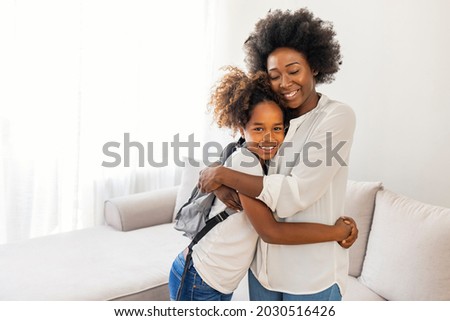 Mom gets daughter ready for school in the morning. Mother preparing her daughter for first day in school. Mother leads little child school girl in first grade. Mother preparing her child for school