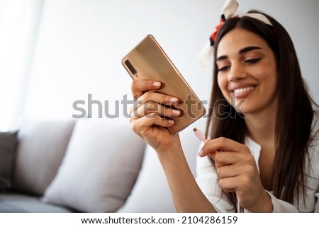 Woman hands plugging a charger in a smart phone. Woman using smartphone with powerbank. Young woman charging power to smart phone. Woman charging battery on mobile phone at home Photo stock © 