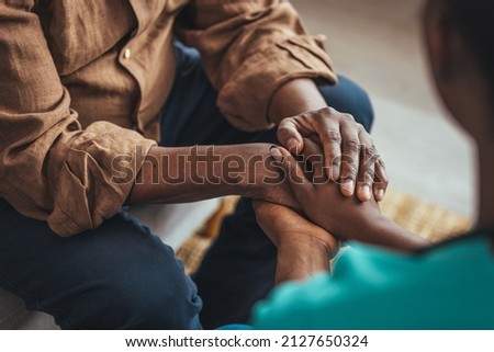 Closeup of a support hands. Closeup shot of a young woman holding a senior man's hands in comfort. Female carer holding hands of senior man  Foto d'archivio © 