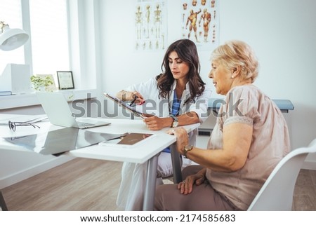 Female doctor explaining diagnosis to her patient. A smiling mid adult female doctor listens as a female patient discusses her health. Caring doctor listens to patient Foto stock © 