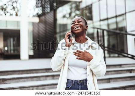 Similar – Image, Stock Photo Cheerful black woman talking on smartphone near sea in sunset
