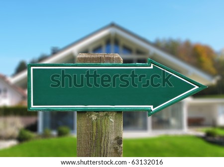Empty road sign against a house