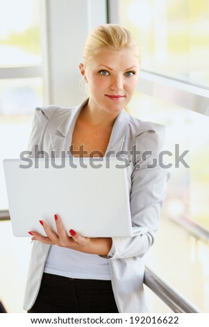 A young woman holding a laptop