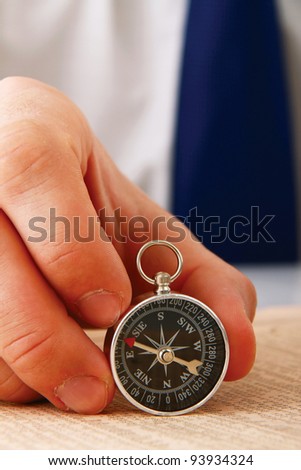 Man\'s hand holding a compass.