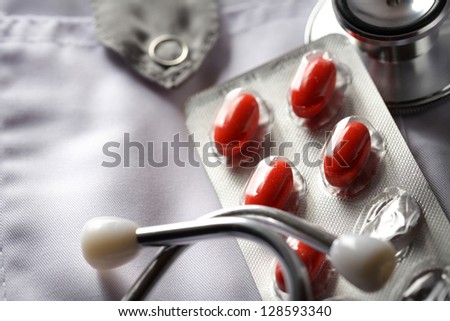 Stethoscope and pills on doctor\'s smock