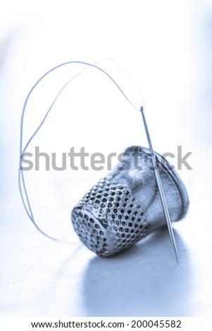 Metal sewing thimble and needle with thread