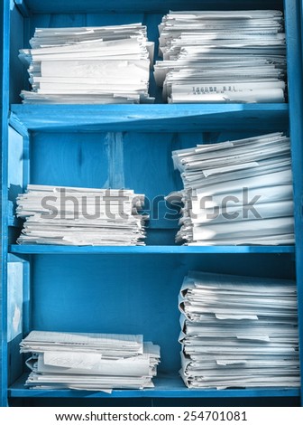 Paper documents stacked in archive on shelf