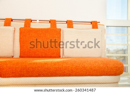 Cozy orange and white sofa with pillows