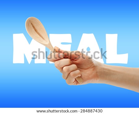 Wooden spoon in female hand in closeup