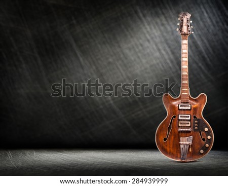 Old electric guitar vertical on steel scratchy background