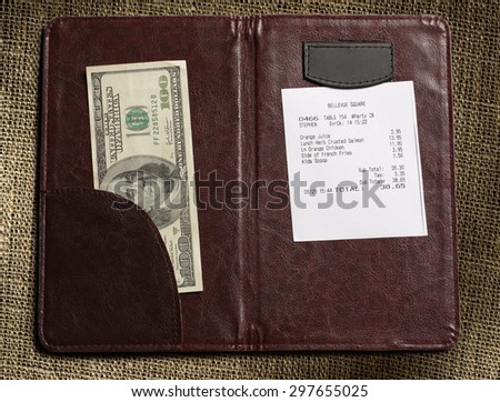 Open check folder with bill and money