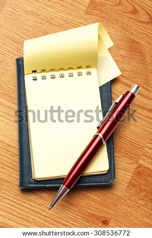 Yellow blank notepad open with red pen