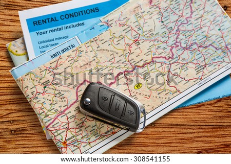 Car remote key on map and rental agreement