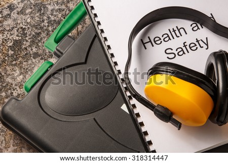 Black toolbox with earphones and health and safety document