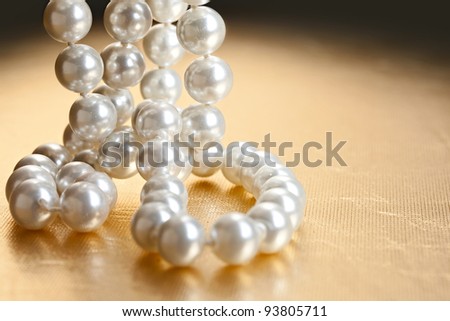 String of pearls on golden surface