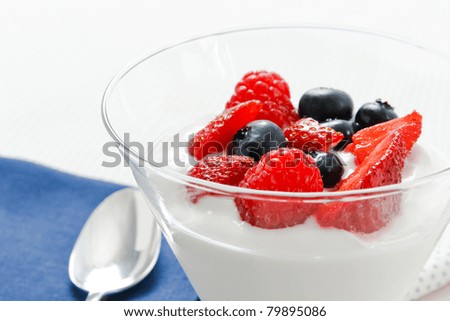 Close up view of berries and yogurt with shallow depth of field and copy space.