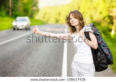 girl with backpack stops the car on road
