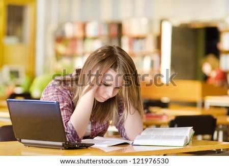 sad student with laptop working in  library