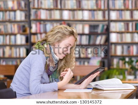 student using a tablet computer in a library