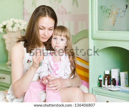 Sick kid with high fever and mother taking temperature