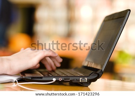 Hands typing on notebook in college class