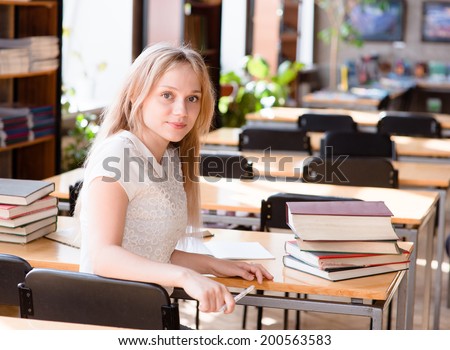 Portrait of a pretty female student studying in library