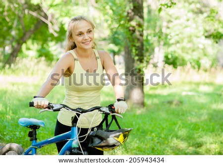 Smiling woman with a mountain bicycle in park