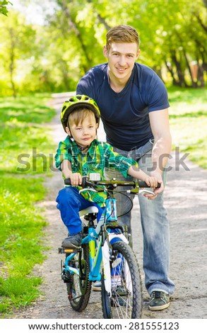 Young father teaches his son to ride a bike