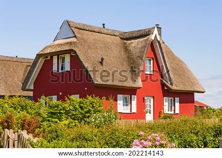 red thatched-roof vacation home with garden