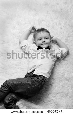 Boy lie on white carpet
