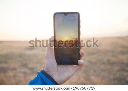 Similar – Image, Stock Photo Man takes a sunset photo on the phone