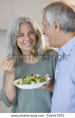 Happy senior couple eating a salad