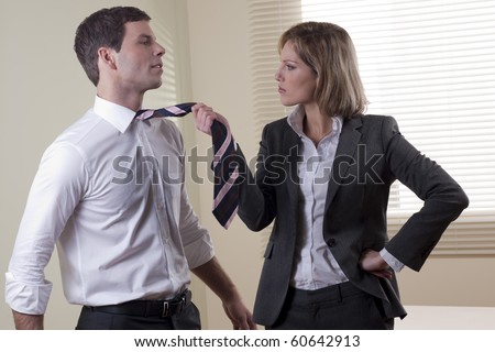 Business woman pulling his colleague from necktie