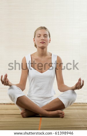 Young woman sitting in lotus position and meditating