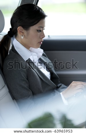 Young chinese business woman inside a car
