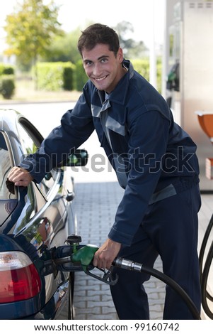 Service station worker filling up car with fuel