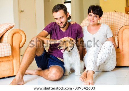 Man and woman in they house playing with the dog