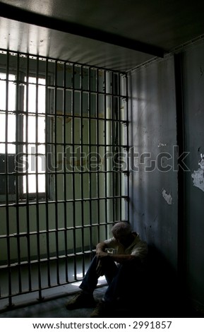 Old deserted jail cell with bars and bleak atmosphere.