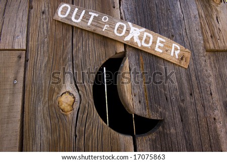 Out of order sign on old outhouse.