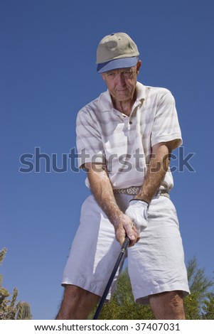 Senior golfer swinging the golf club on a summer day