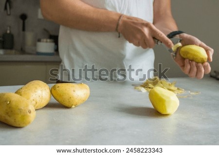 Similar – Image, Stock Photo Unrecognizable chef peeling potato in kitchen