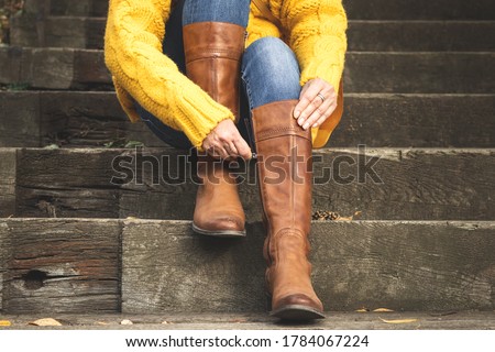 Similar – Image, Stock Photo Woman in brown boots standing on a wooden floor holding a dried artichoke flower in her hand