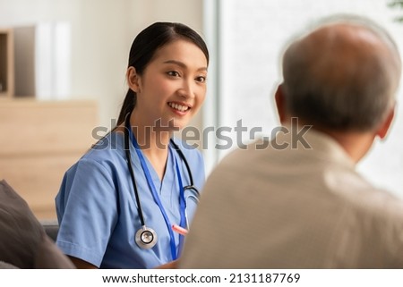 Asian doctor woman visited senior or elderly patient to diagnosis and check up health at home.Happy elderly enjoy cheerful with doctor or nurse on couch.Health care premium service at home Stock fotó © 