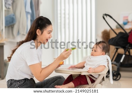 Similar – Image, Stock Photo Mom feeds her little son sitting on a chair in the kitchen