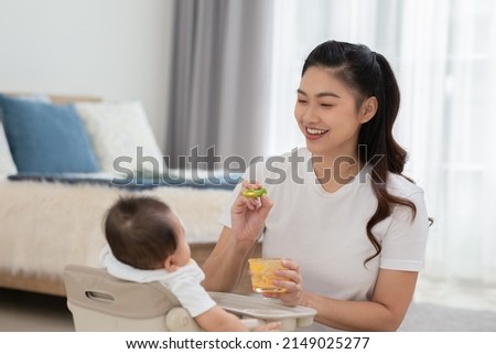 Similar – Image, Stock Photo Mom feeds her little son sitting on a chair in the kitchen