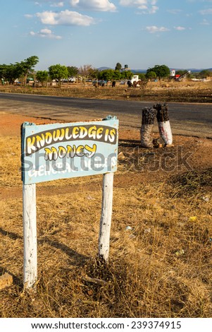 Road sign with charcoal bags along the road in africa, Tanzania