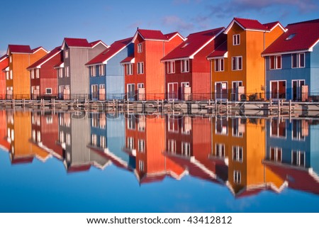 Colorful wooden houses near water in the morning sun