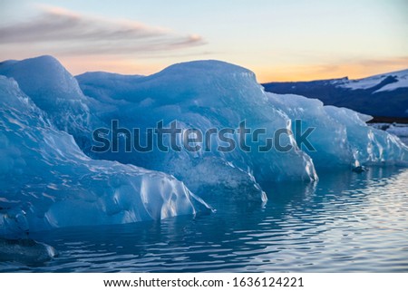 Icebergs floating.  Ices and icebergs. Glacier lagoon. Greenland iceberg. Melting ice. South coast Iceland. Jokullsarlon glacier lagoon. Volcanic ash on the ice. Ice age glacier. Melting iceberg.
